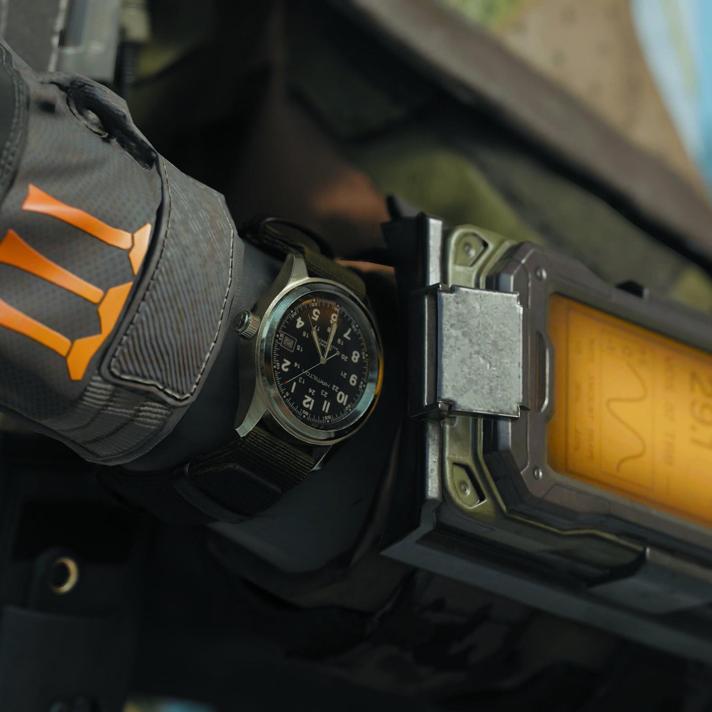 Watch on a gloved hand with a crossbow in the background