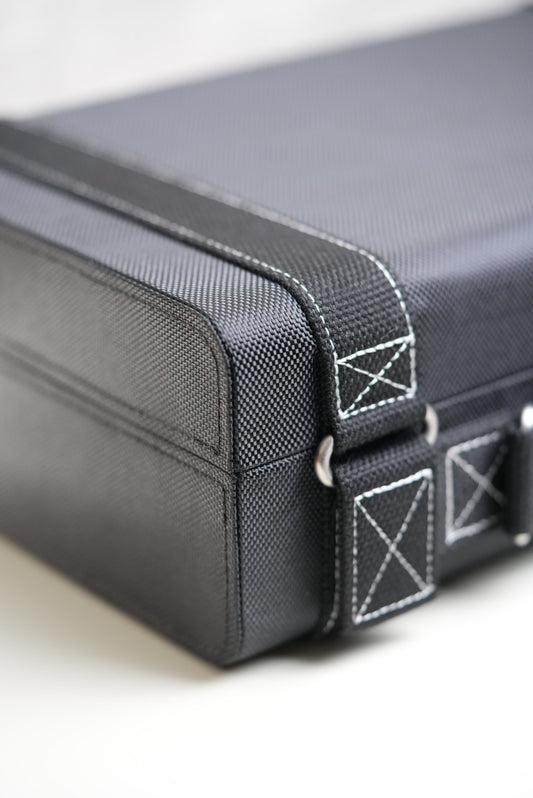 Close-up of a gray suitcase with a strap and brand logo.