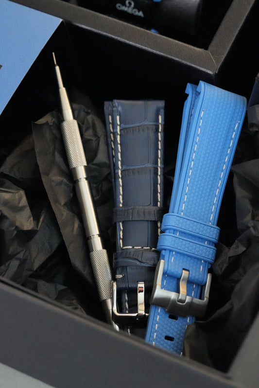 Blue watch strap with silver hardware on a black background