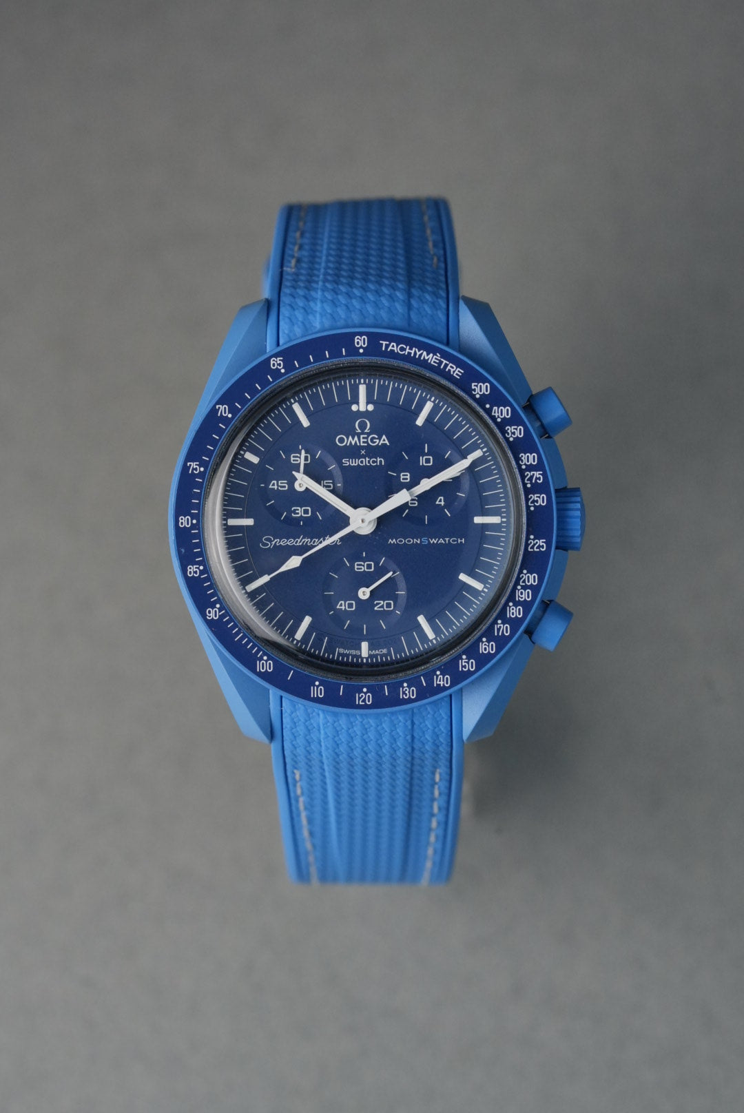 Blue watch with detailed face on a gray background