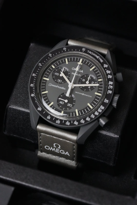 Black Omega watch with detailed face on a dark background