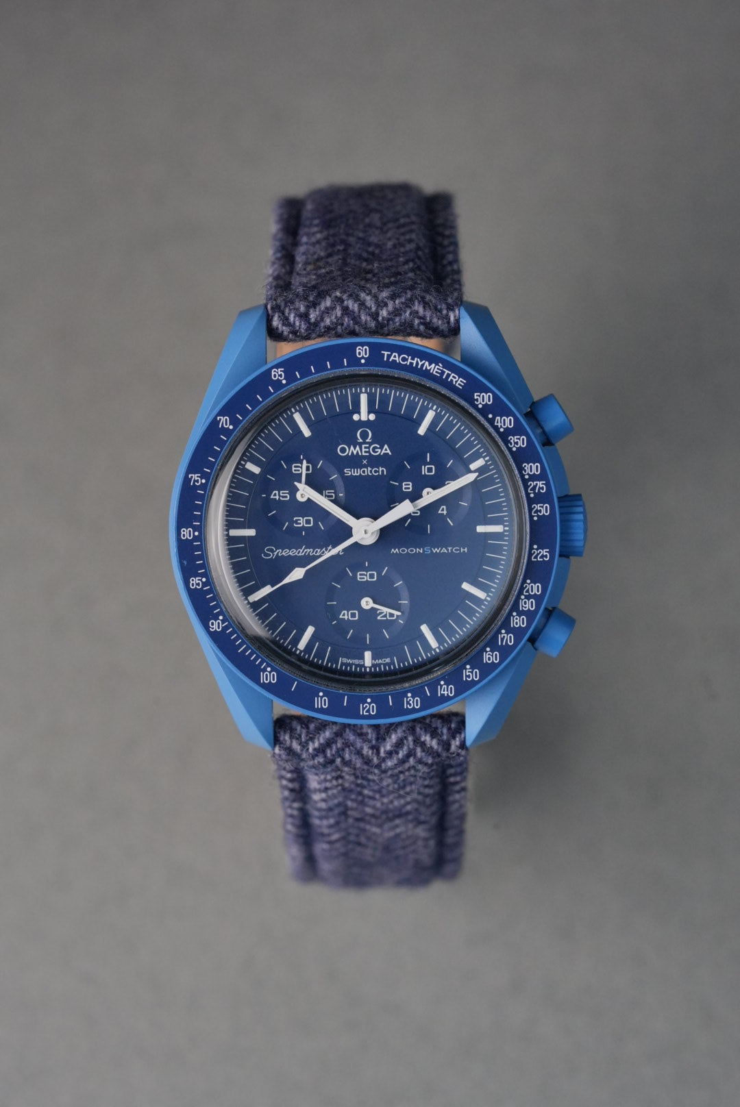 Blue watch with detailed face on a gray background