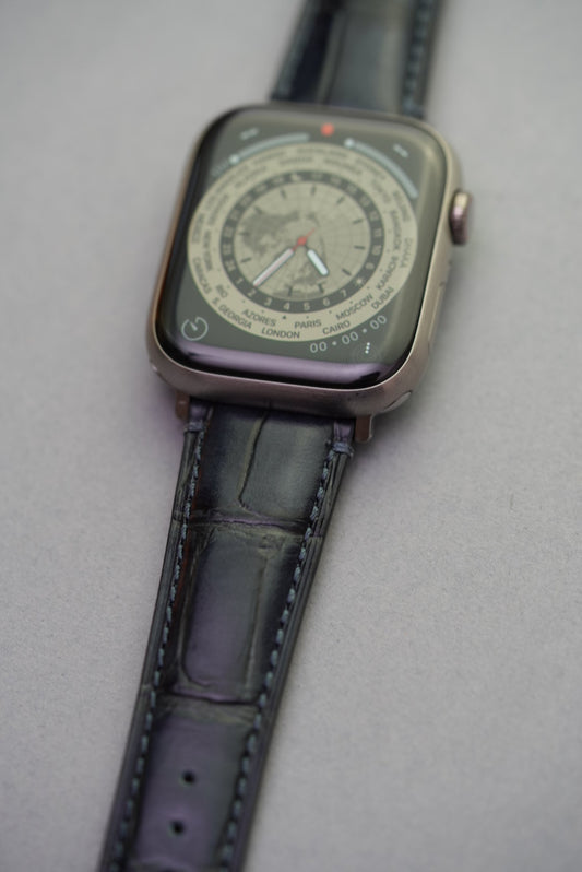 Side angle of black embossed alligator calfskin leather strap fitted to Apple Watch, showing curvature and texture.