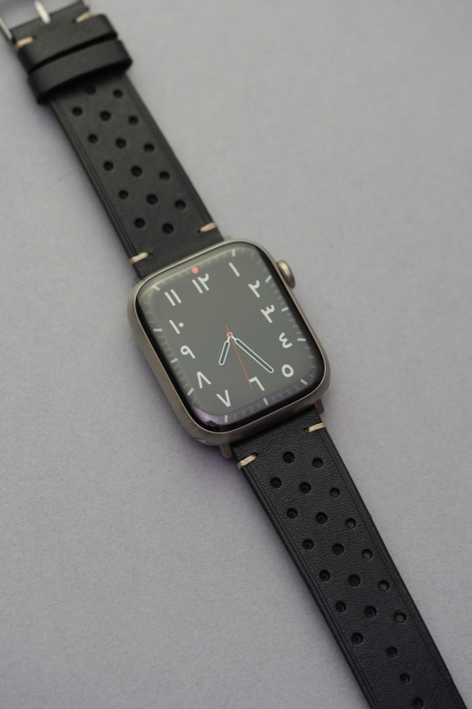 Black perforated leather strap fitted to Apple Watch face for strap replacement