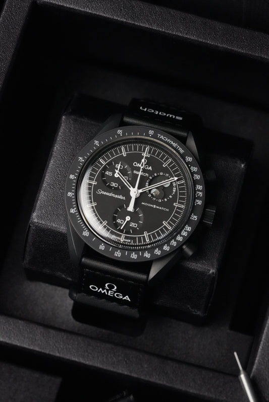 Close-up of Swatch x OMEGA MoonSwatch Black Snoopy dial inside presentation case.