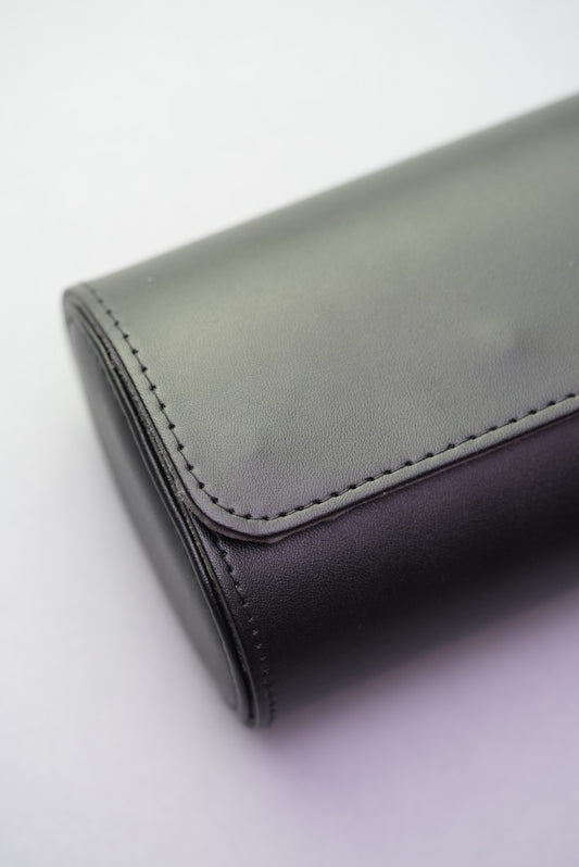 Close-up view of the end stitching and curve on the black vegan leather travel watch roll.