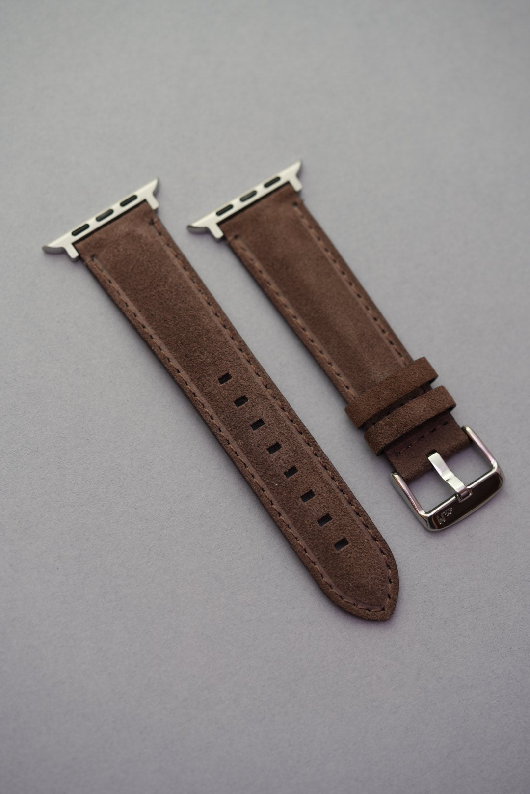 Brown suede leather strap with Apple Watch adapters laid flat – fits all Apple Watch series