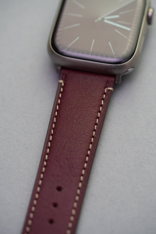 Burgundy leather strap fitted on Apple Watch showing sleek integration and contrast stitching