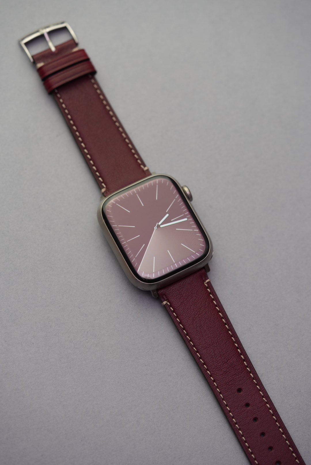 Burgundy Fine Grain Calfskin Strap fitted to Apple Watch, shown with brushed stainless steel buckle