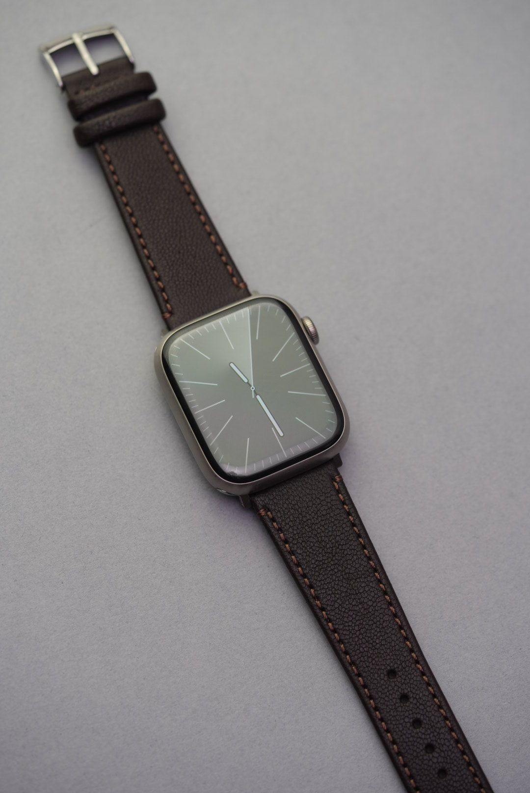Full-length view of the Cortado Chestnut strap paired with Apple Watch, featuring deep brown grain and mocha stitching.