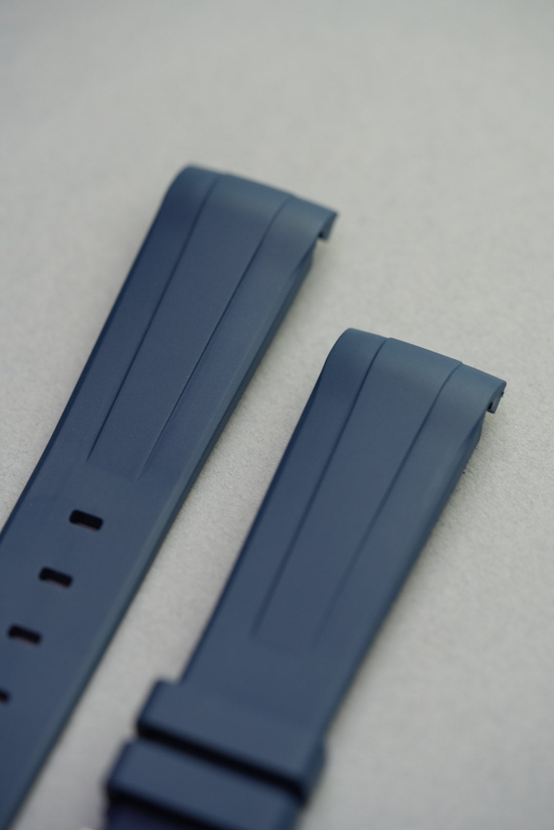 Close-up of unmounted FKM curved rubber strap in blue, showing clean lines and lug curvature.