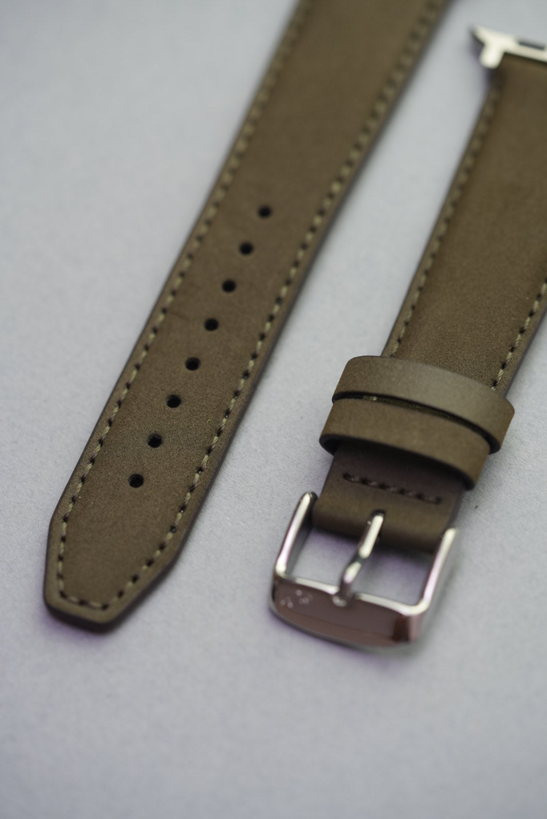Olive nubuck leather strap on an Apple Watch, showcasing minimal stitching and clean lines.