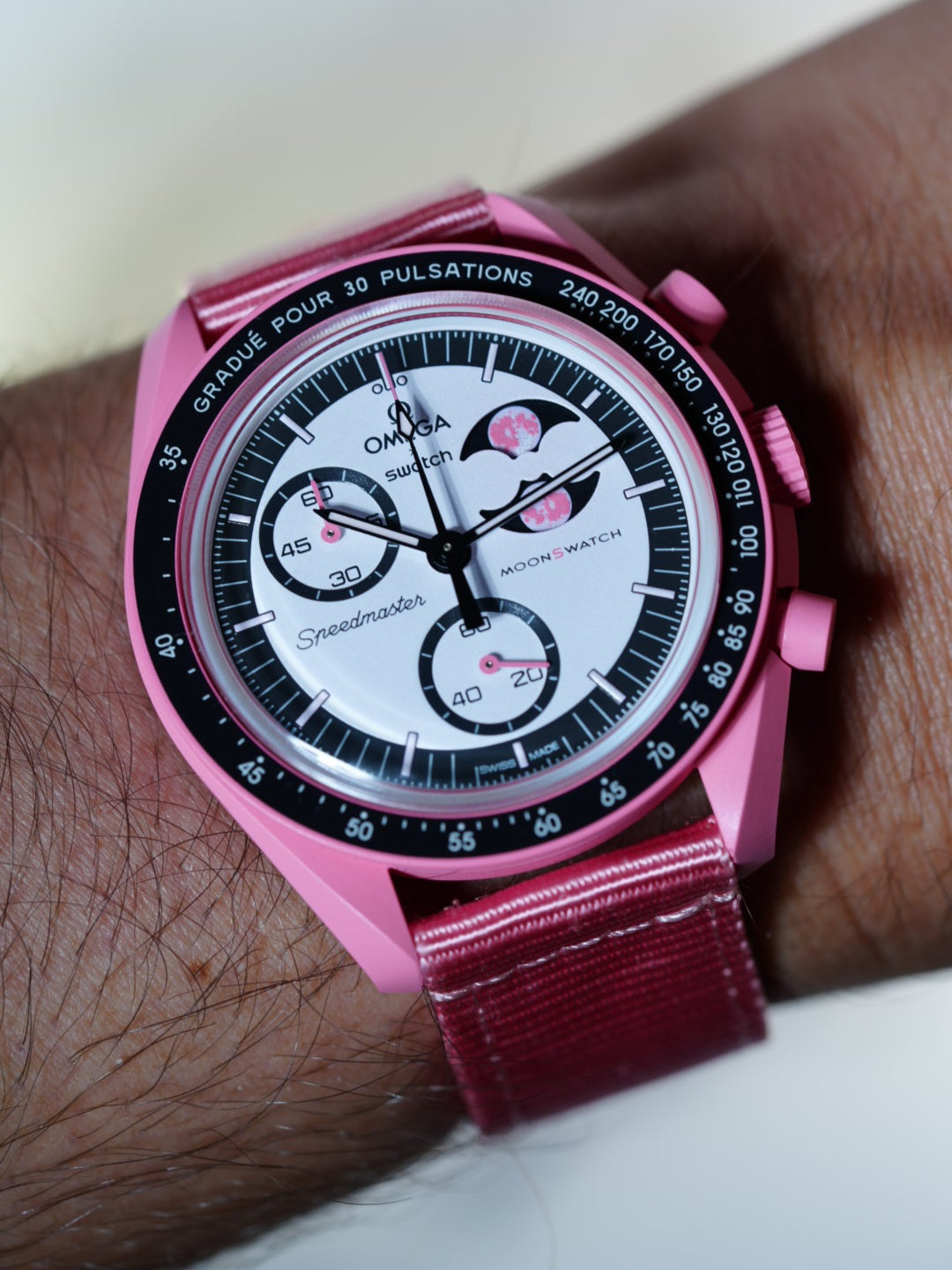 Mission to the Pink Moonphase worn with a two-piece pink nylon strap – lightweight, breathable and colour-matched for a seamless fit.