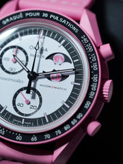 Macro close-up of the Omega x Swatch Pink Moonphase dial showing moonphase window, pink planet detail, and chronograph subdials.