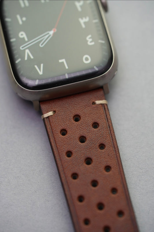 Perforated brown leather strap mounted on Apple Watch face