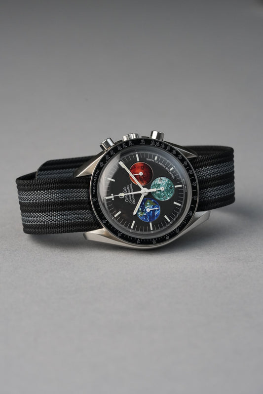 Wristwatch with black strap and detailed face on a gray background