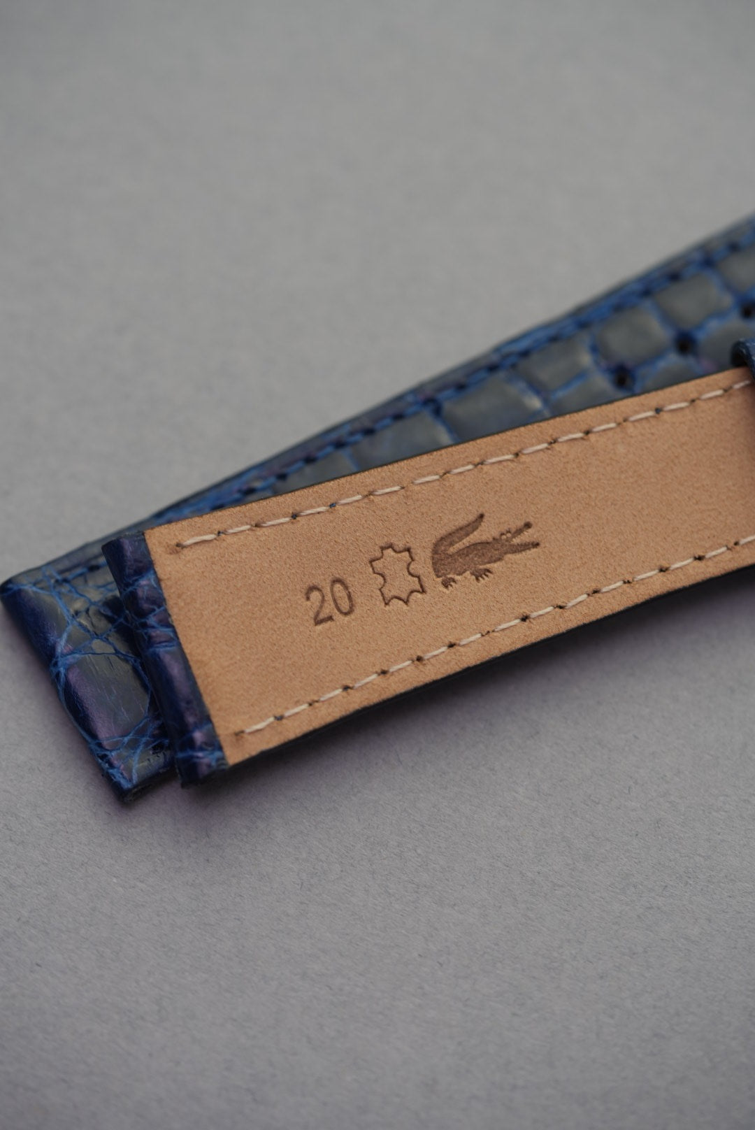 Underside of sapphire blue crocodile leather watch strap showing 20mm lug width and natural leather lining.