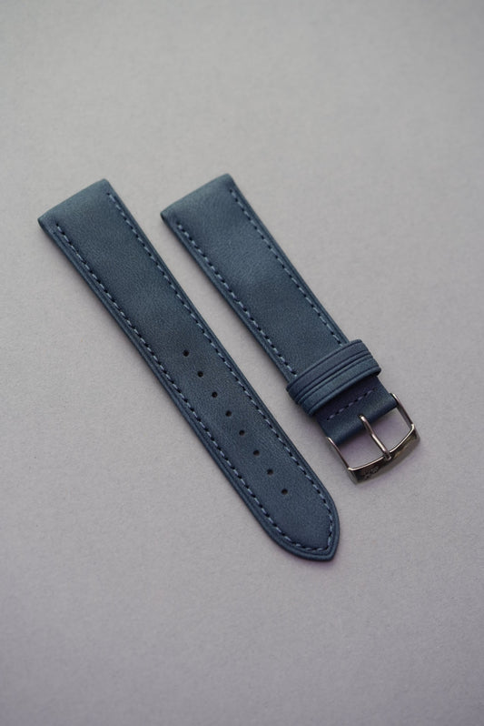 Navy blue suede watch strap displayed flat with matte texture and stitching detail.