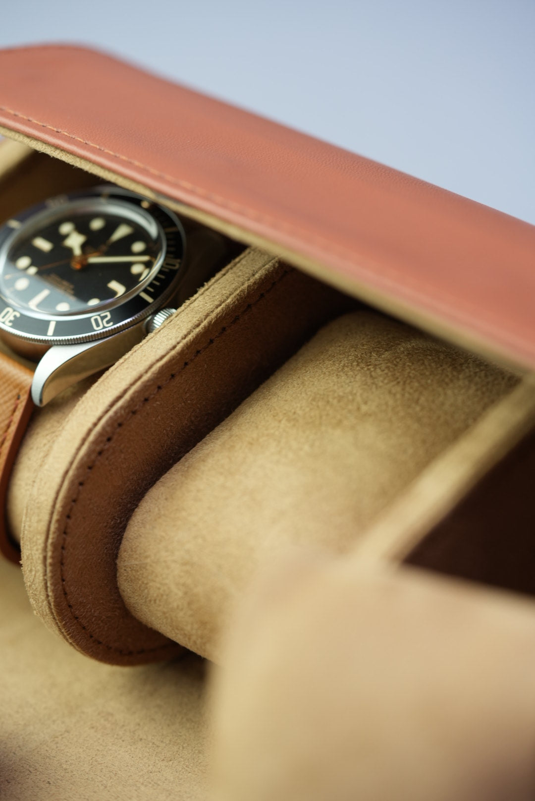 Macro detail of interior suede padding inside the three-slot tan watch roll.