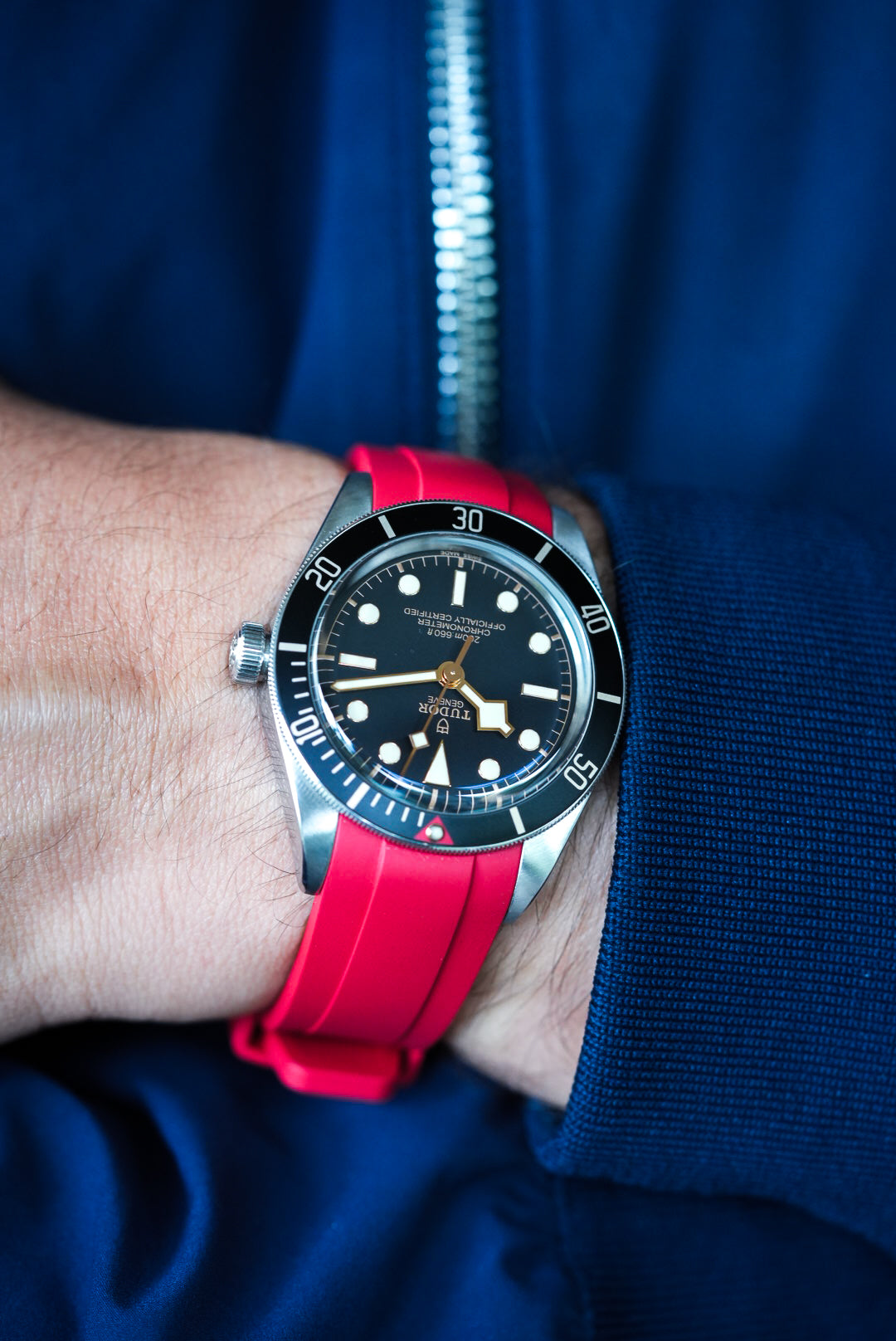 Tudor Black Bay with red FKM rubber strap shown in a relaxed wrist pose – premium strap pairing with bold colour.