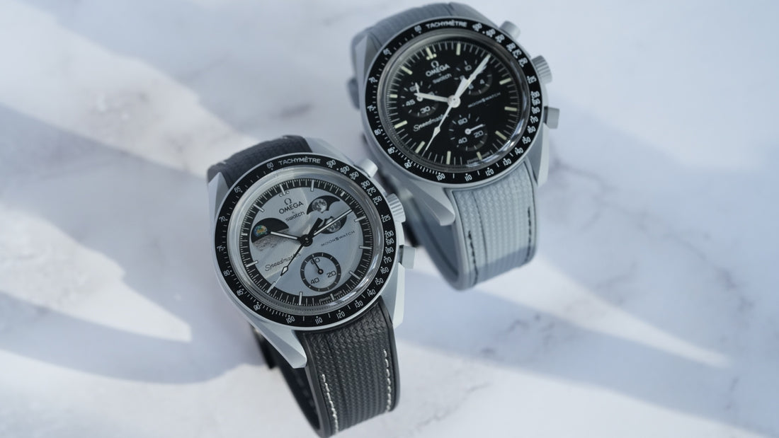 Swatch x OMEGA MoonSwatch Mission to Earthphase watches featuring grey and black rubber straps, showcasing Bioceramic cases with Earthphase indicators on a light marble background