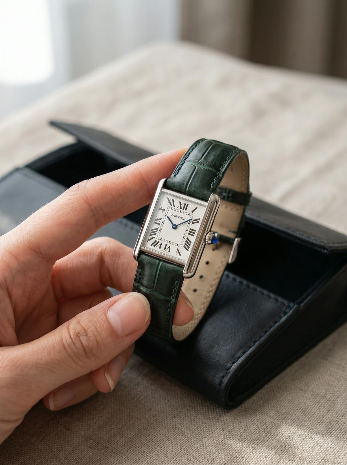 Cartier Tank Must Small on a green square alligator-grain leather strap, held in hand