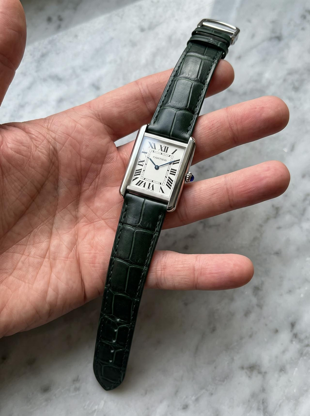 Cartier Tank Solo Large on a green square alligator-grain leather strap, held in hand