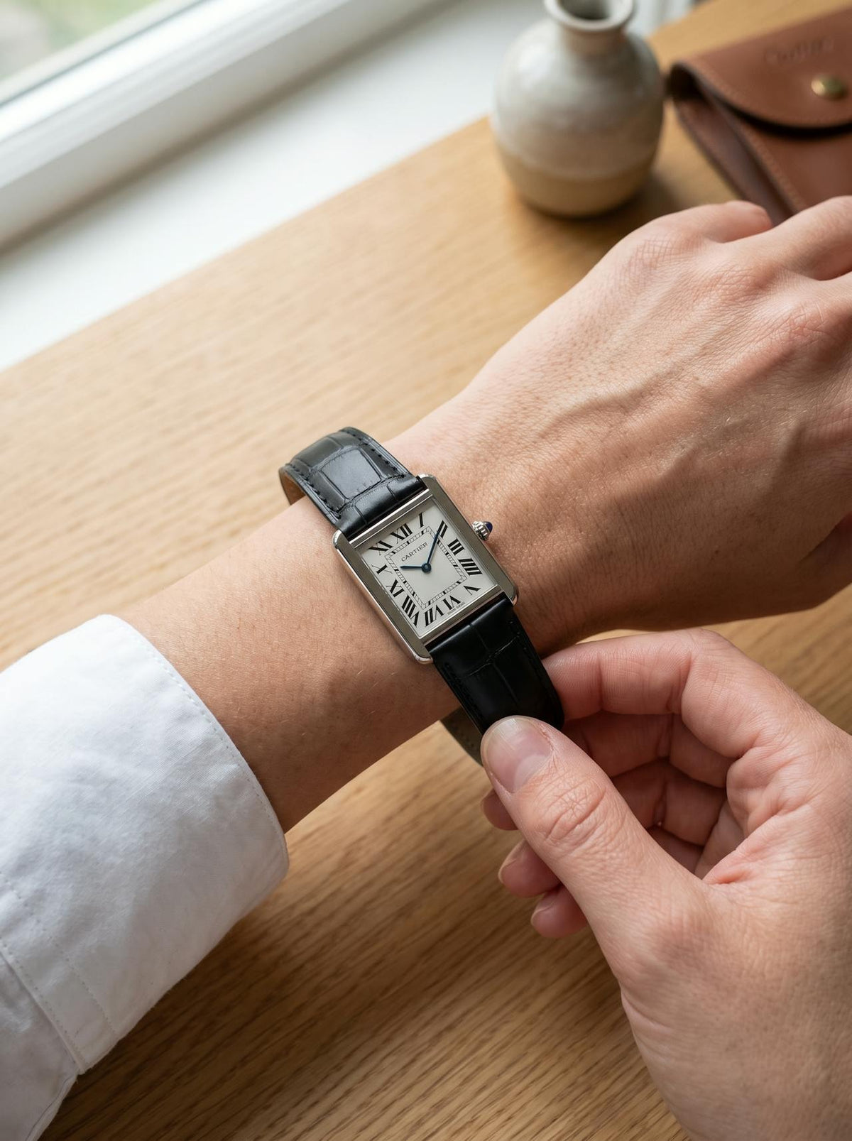 Cartier Tank Solo Small on a black square alligator-grain leather strap, worn on the wrist