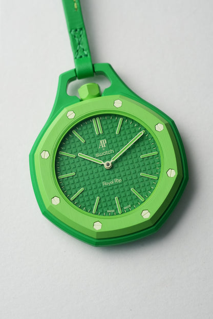 Green watch with a textured face on a light gray background