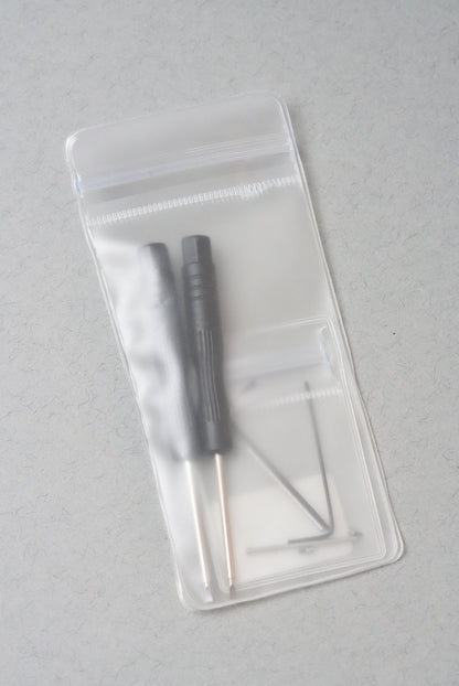 Two small tools in a clear plastic case on a gray background