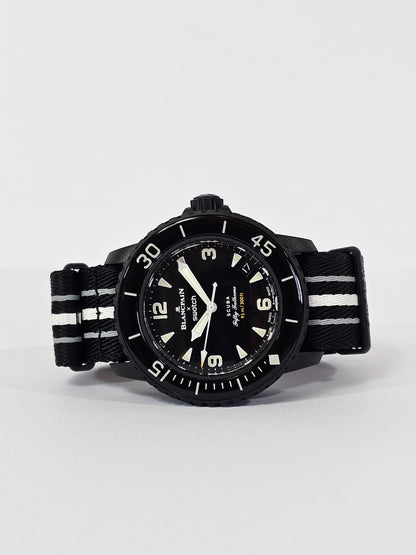 A black analog watch with a date display, a rotating bezel, and a strap made from recycled materials.