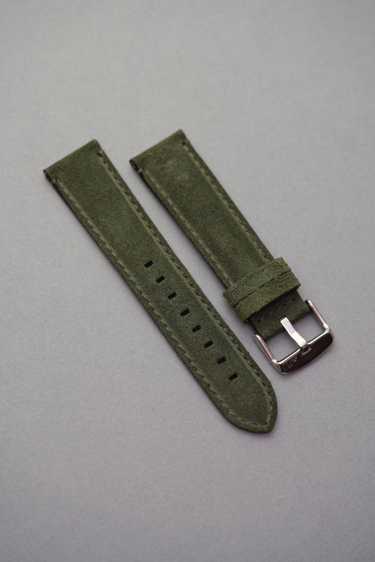 Green suede leather watch strap laid flat with stainless buckle for strap replacement