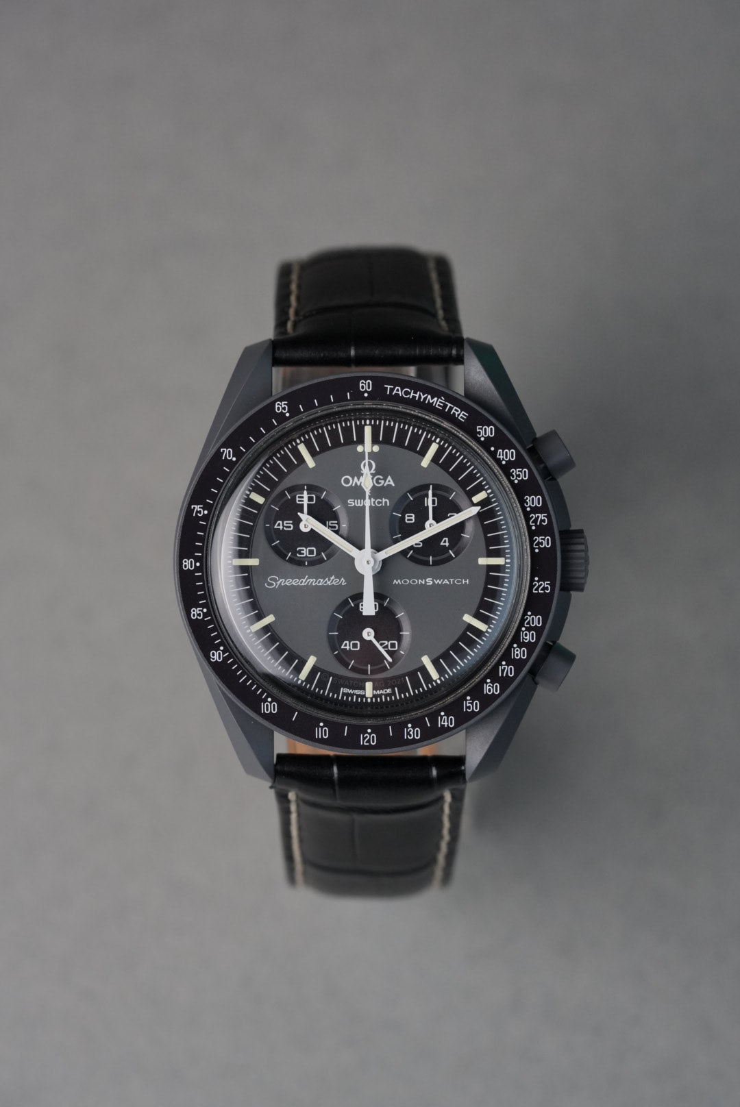 Black watch with detailed face on a gray background