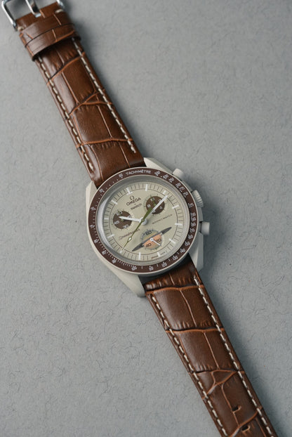 Wristwatch with brown leather strap on a gray background