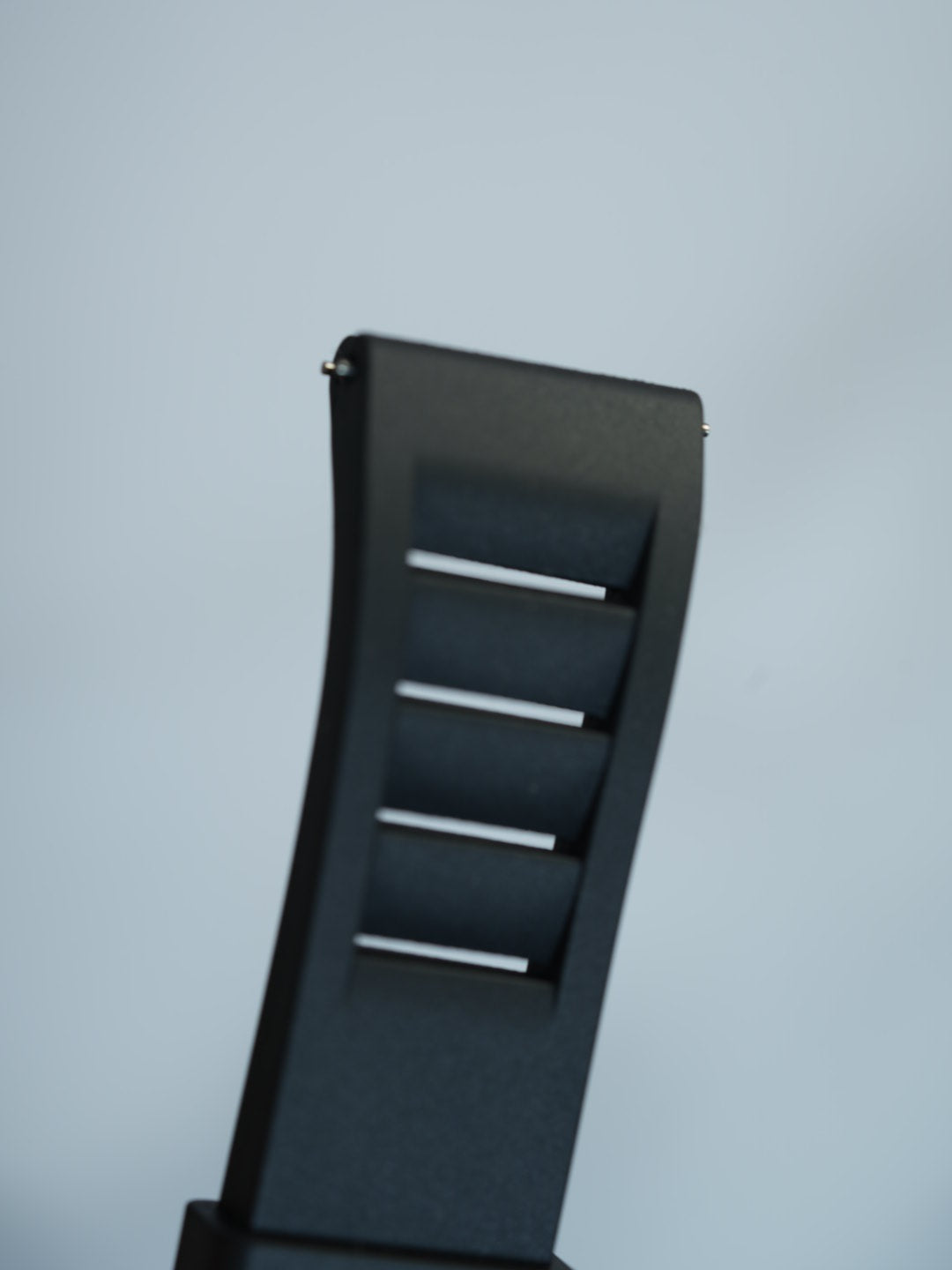 Close-up of the black vented FKM rubber strap on a wrist, emphasizing its soft texture, waterproof capability, and flexible design