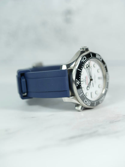 Side view of the Omega Seamaster on a wrist, highlighting the snug fit and smooth texture of the Navy FKM rubber strap.