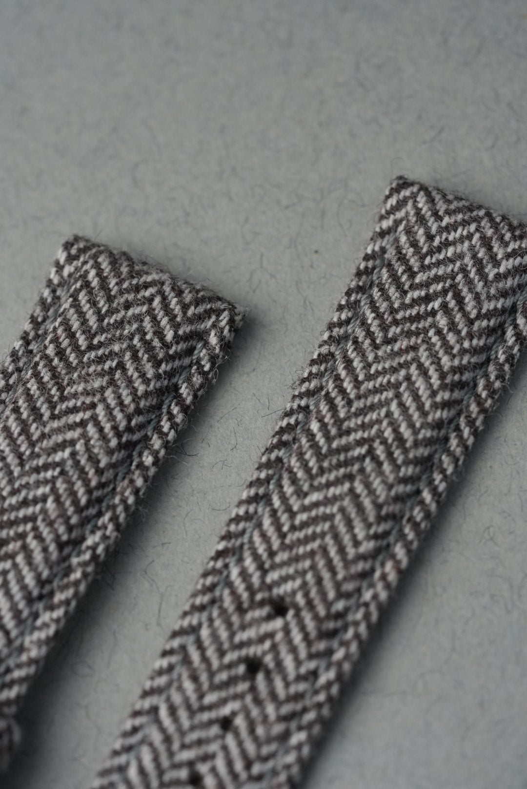 Two herringbone-patterned ribbons on a gray background