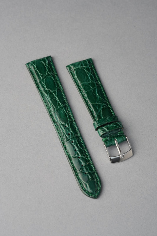 Green crocodile-patterned watch strap on a gray background. Buy strap replacement