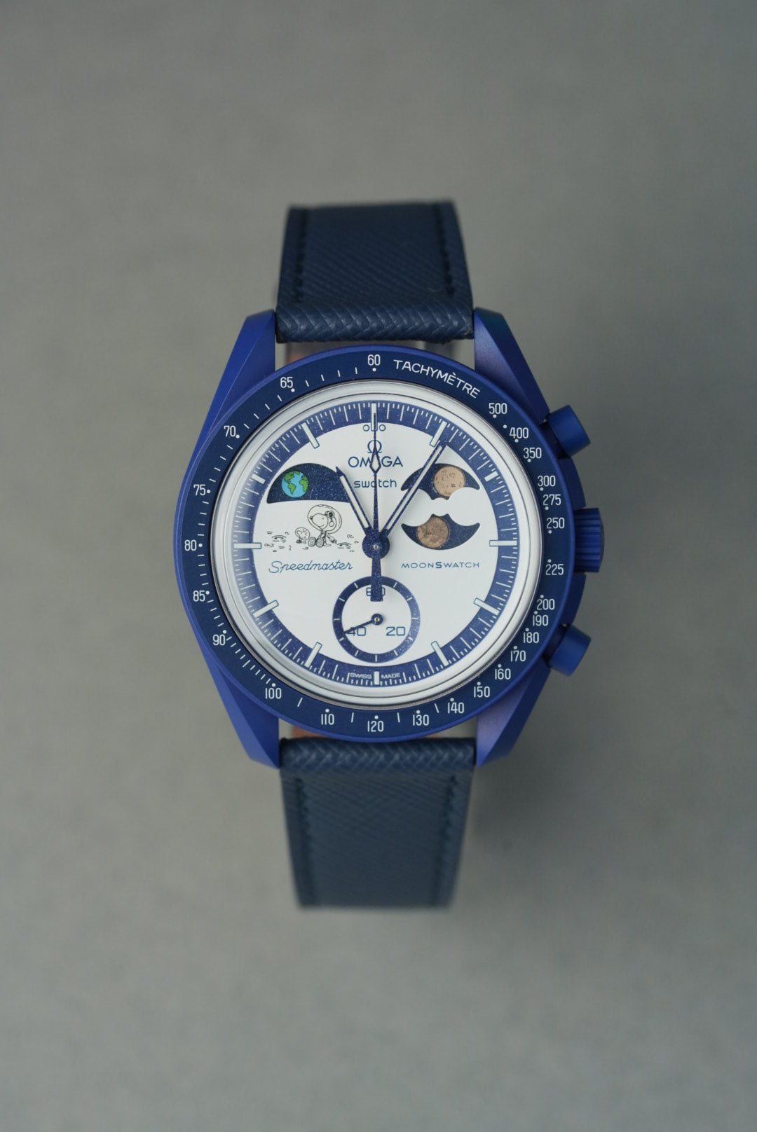 Blue wristwatch with detailed face on a gray background