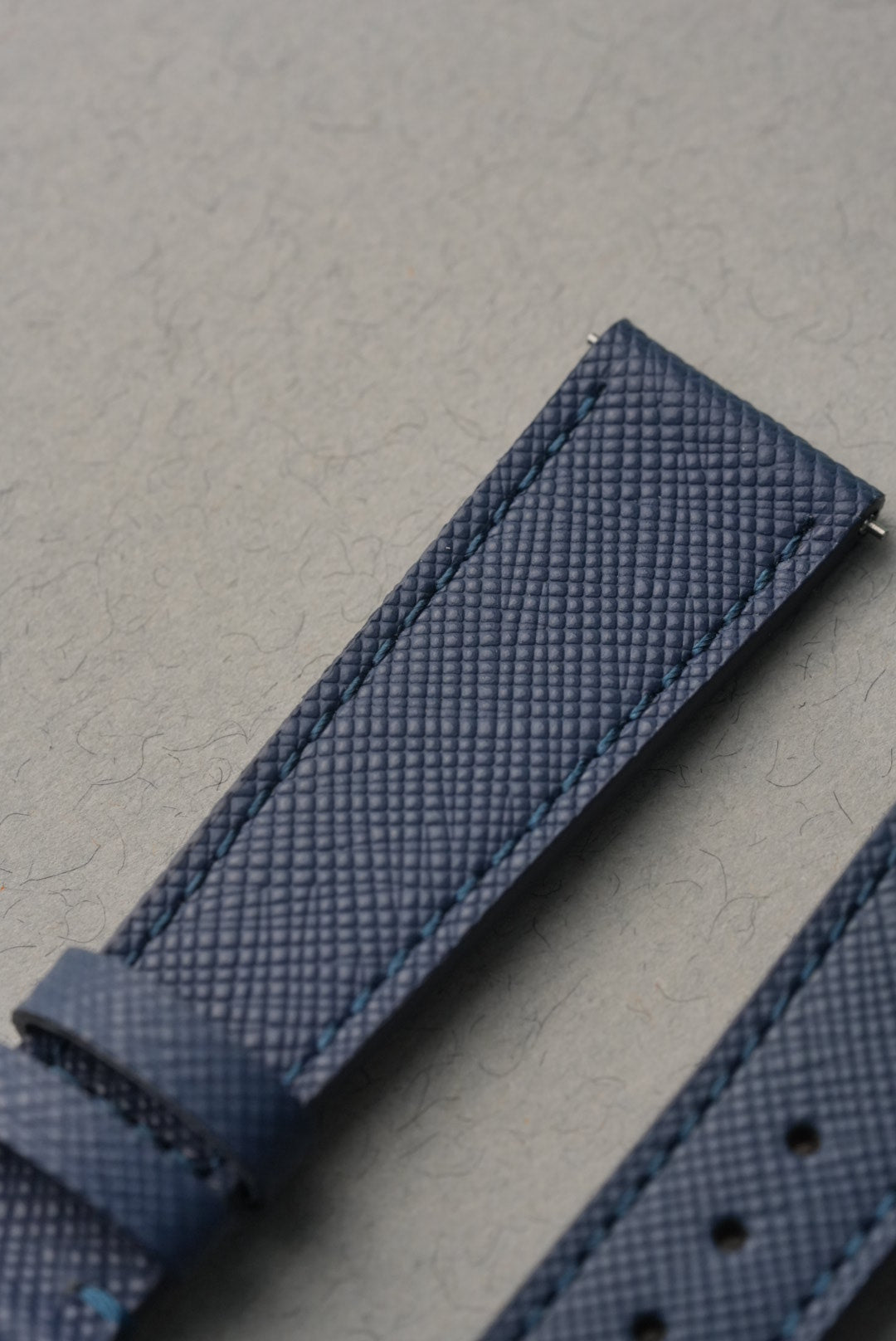Close-up of a textured blue strap on a gray background