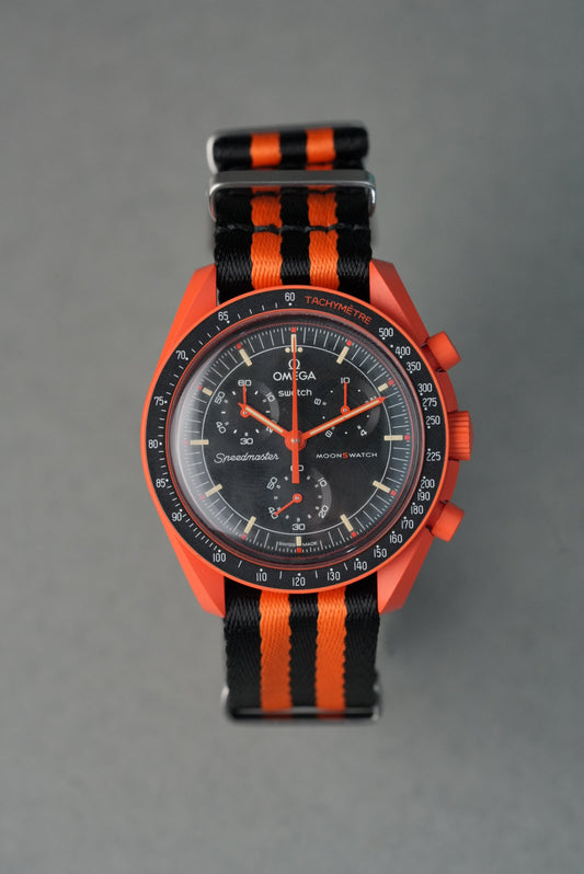 Omega watch with orange and black striped strap on gray background