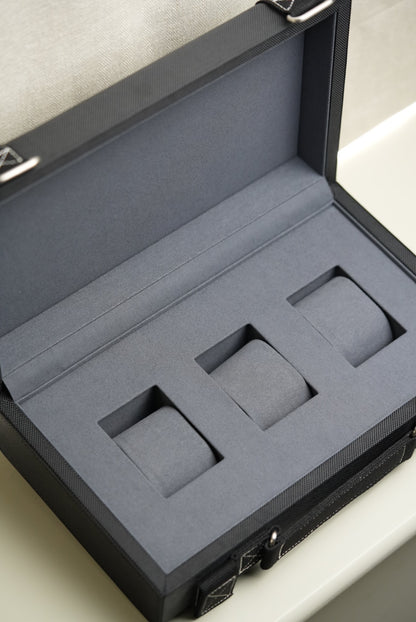 Gray foam-lined jewelry box with compartments on a light background