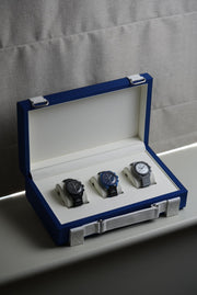 Set of watches in a blue and white box on a gray surface