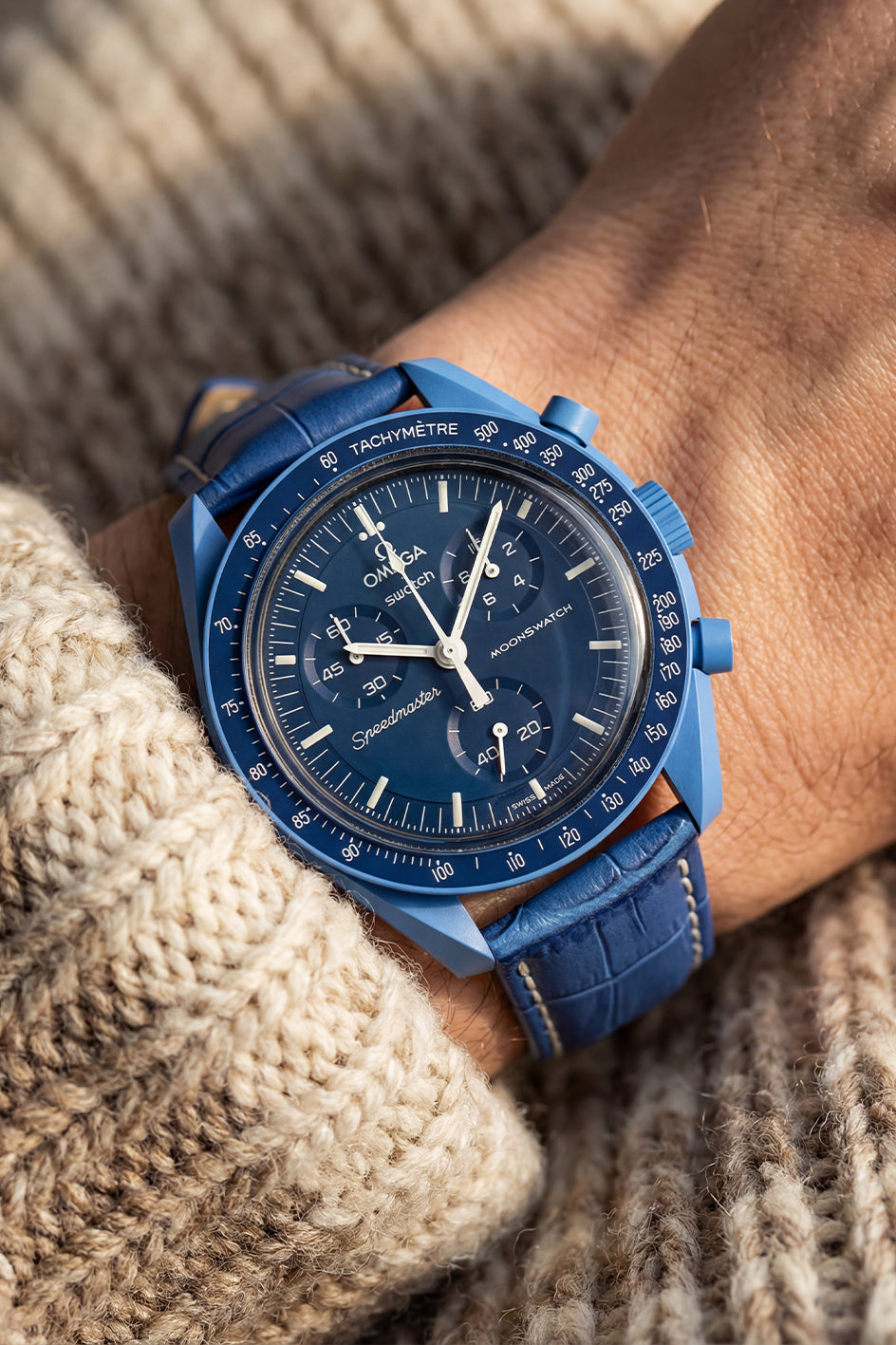 Blue wristwatch on a person's wrist with a textured background