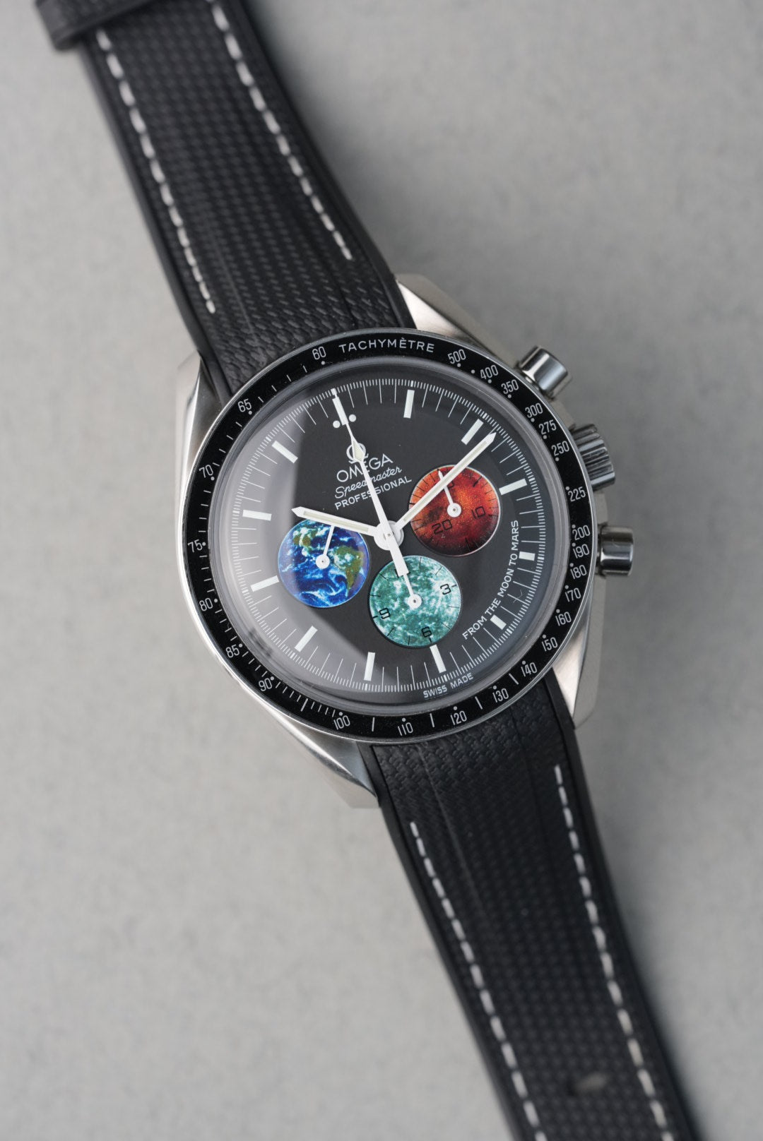 Watch with a black strap and detailed face on a gray background