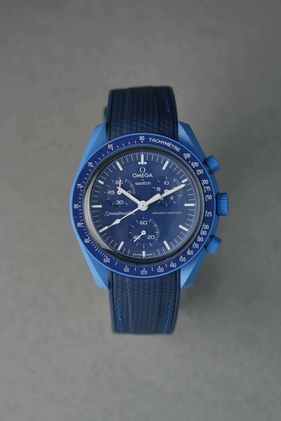 Blue watch with detailed face on a gray background