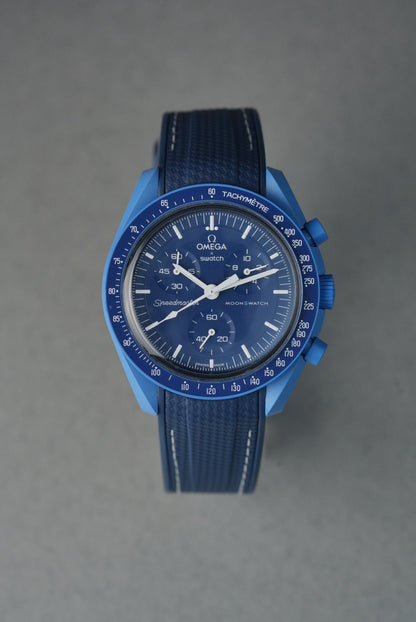 Blue watch with a textured strap on a gray background