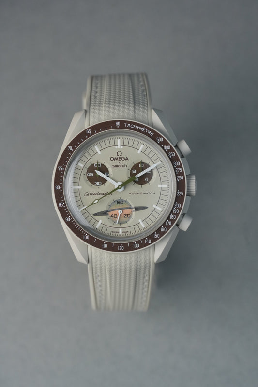  Beige rubber woven MoonSwatch strap with matching stitching and curved fit for a subtle, neutral aesthetic.