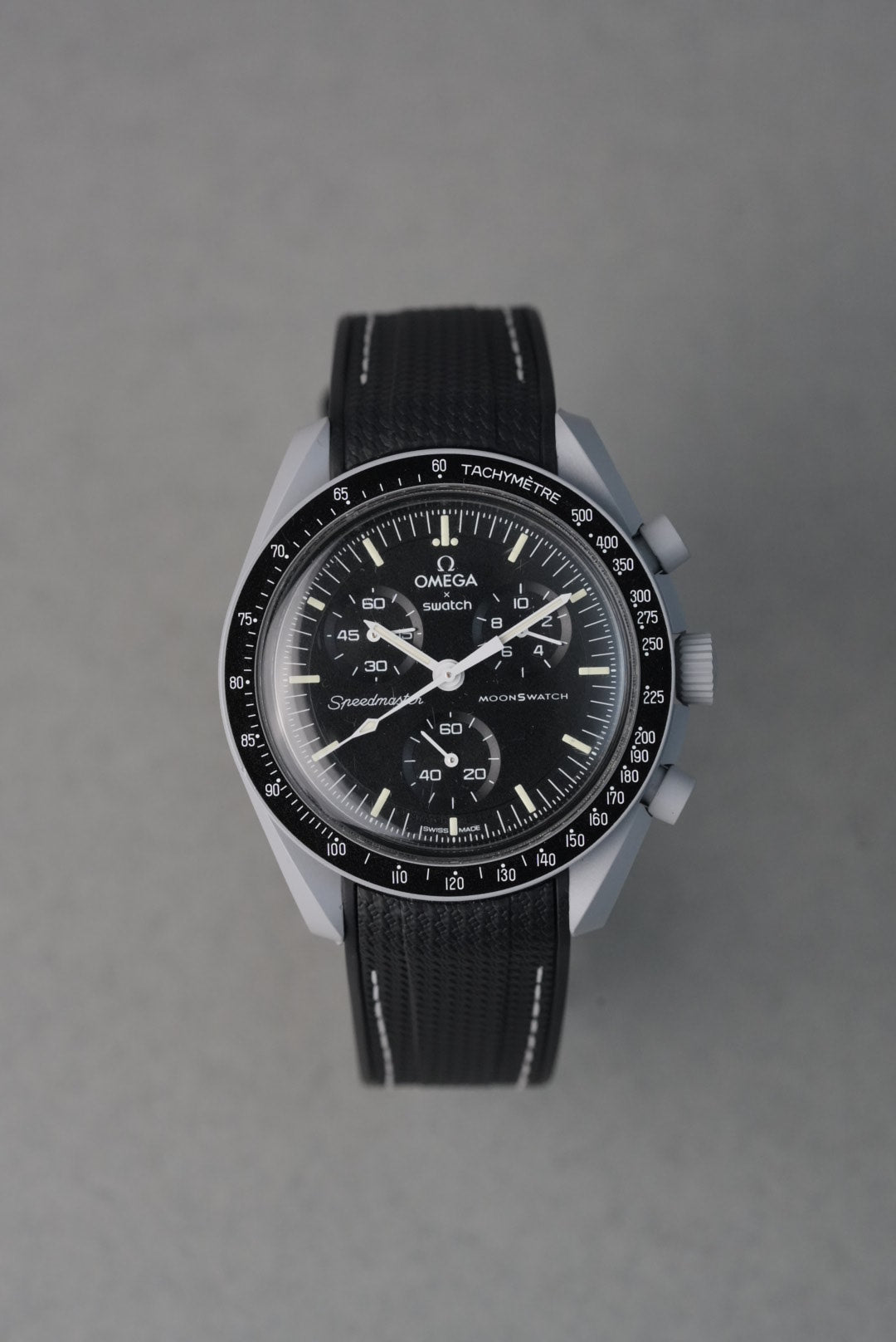 Black wristwatch with detailed face on a gray background