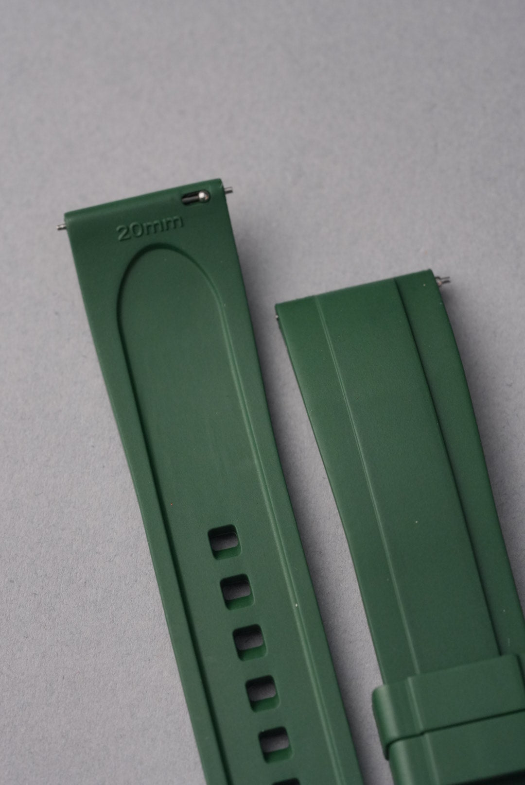 Green watch strap on a gray background
